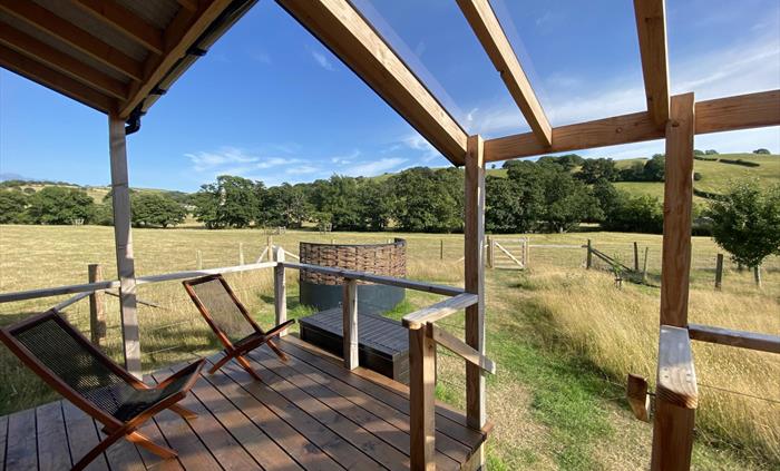 Unique cabin with outdoor deck and verandah overlooking meadow, perfect for relaxation or yoga.